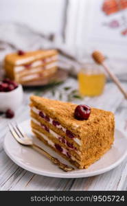 Homemade honey cake with cherry on plate