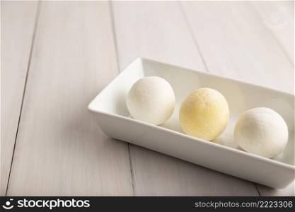 Homemade ice cream Mochis. Traditional Japanese dessert made from rice flour. Close up on white wooden surface with copy space. 