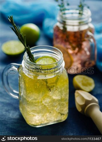 Homemade Iced fizzy Sparkling lemonade with lemon, rosemary and thyme in Mason jar