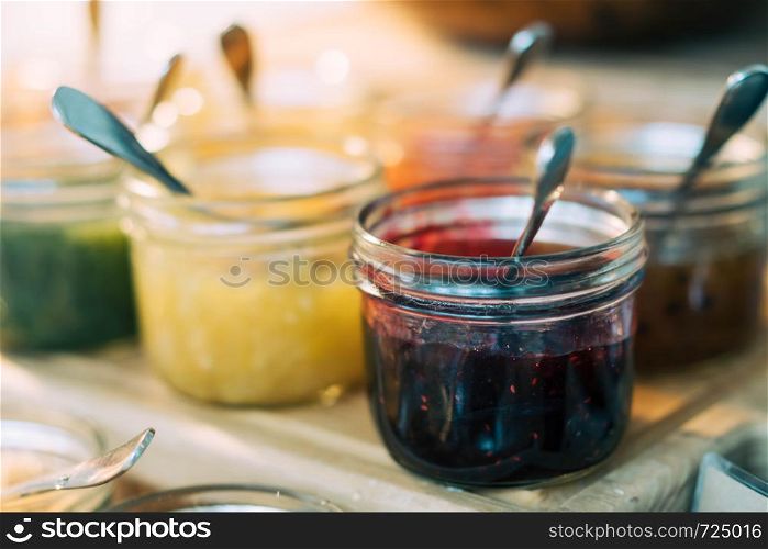 Homemade jars of variety fruits jam on the table