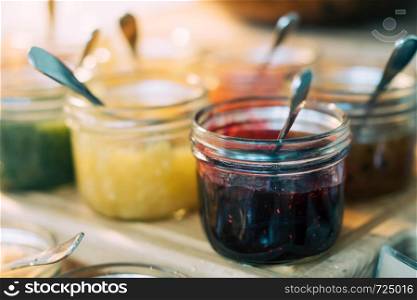 Homemade jars of variety fruits jam on the table