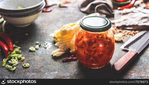Homemade kimchi , fermented chinese cabbage marinated in hot chili sauce in jar on rustic background with ingredients. Healthy asian food