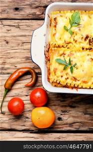Homemade lasagna on wooden table. Traditional italian lasagne food, in a baking dish