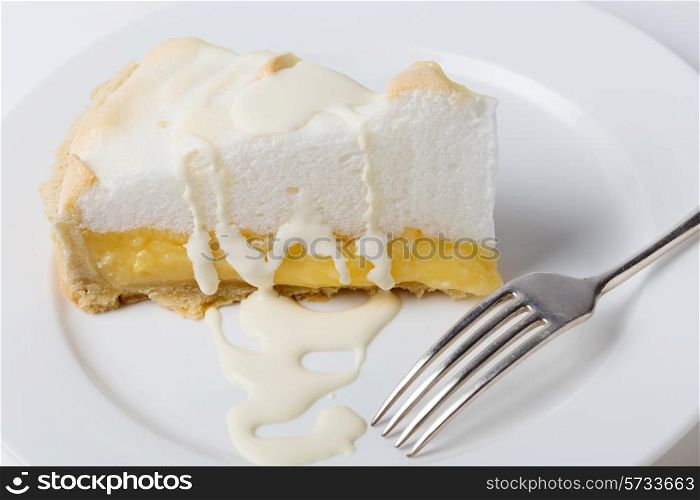 Homemade lemon meringue pie, a classic of European dessert cuisine,served with double cream