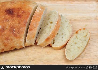 Homemade loaf of bread and slices on wooden board