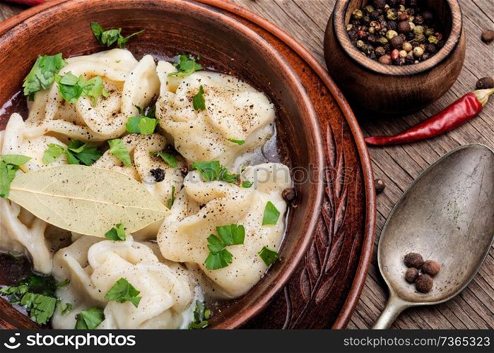 Homemade manti dumplings.Delicious dumplings in the bowl on the table. Dumplings on a plate