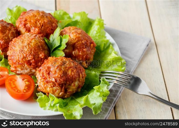 Homemade meat balls with vegetables in tomato sauce. Appetizing protein dish on a white plate.. Homemade meat balls with vegetables in tomato sauce. Appetizing protein dish on a plate.