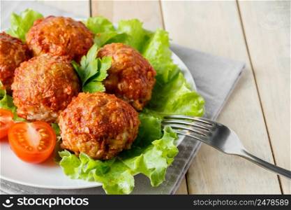 Homemade meat balls with vegetables in tomato sauce. Appetizing protein dish on a white plate.. Homemade meat balls with vegetables in tomato sauce. Appetizing protein dish on a plate.