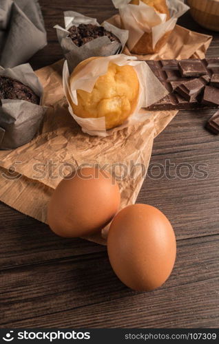 Homemade muffins with chocolate and baking ingredients.