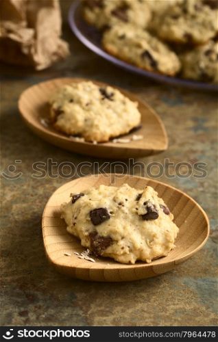 Homemade oatmeal and chocolate cookie on small bamboo plates, photographed with natural light (Selective Focus, Focus on the front of the first cookie)