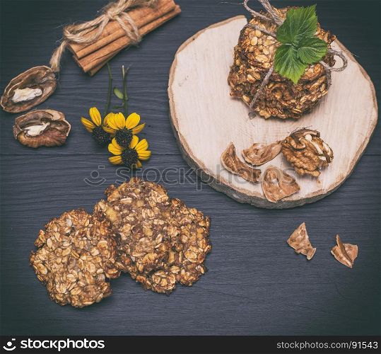 homemade oatmeal cookies on a black wooden background, top view, vintage toning