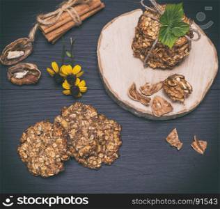 homemade oatmeal cookies on a black wooden background, top view, vintage toning