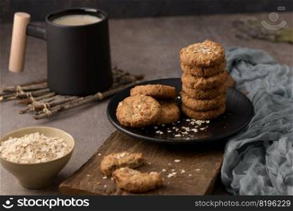 Homemade oatmeal raisin cookies with cup of cappuccino on rustic background.
