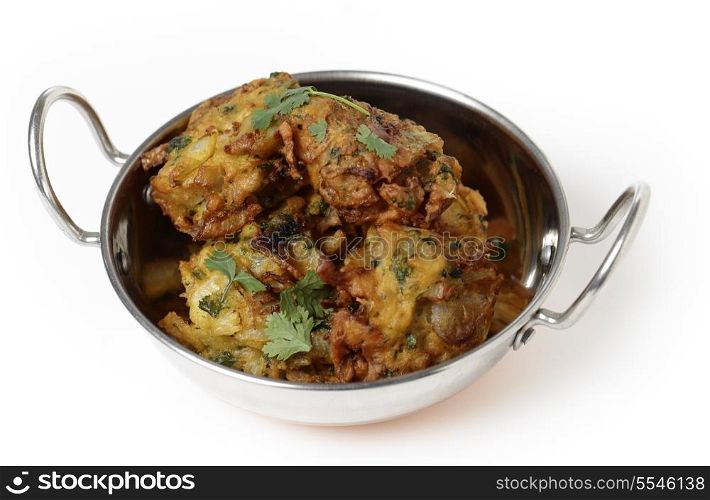 Homemade onion bhajis, an Indian appetiser, served in a kadai or karahi wok.
