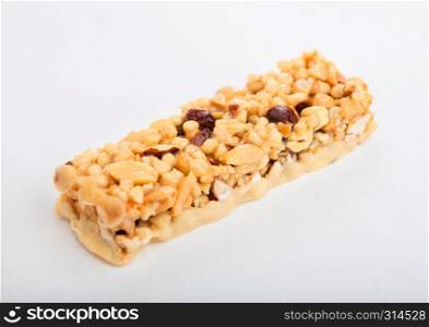 Homemade organic granola cereal bar with nuts and dried fruit on white.