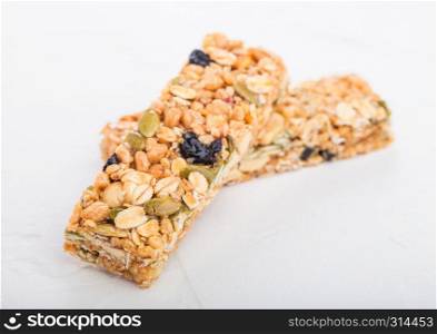 Homemade organic granola cereal bars with nuts and dried fruit on white.