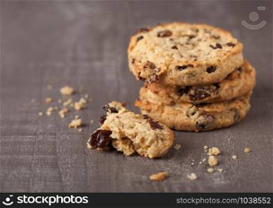 Homemade organic oatmeal cookies with raisins and apricots on grey wood background.