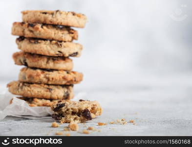 Homemade organic oatmeal cookies with raisins and apricots on light kitchen background.