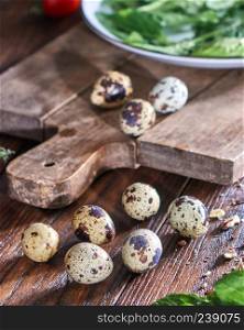 Homemade organic quail eggs, herbs in the plate and pieces of walnut on a wooden table. Healthy Salad Ingredients. Quail eggs and greens in a plate on a wooden table. Ingredients for Making Healthy Salad