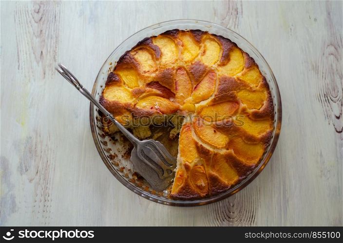 Homemade peach cake ready to serve and on table, top view,