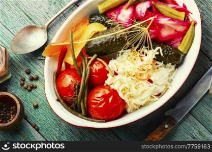 Homemade pickled cucumbers, okra, bell peppers, tomatoes and sauerkraut. Appetizing pickles.. Pickled vegetables and sauerkraut.