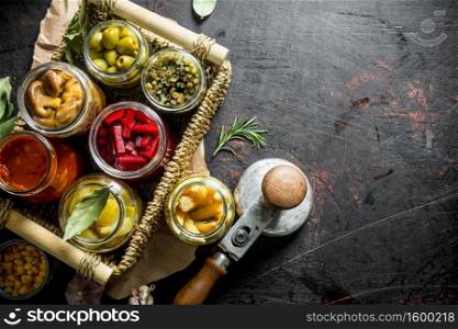Homemade pickled vegetables in jars on the tray. On dark rustic background. Homemade pickled vegetables in jars on the tray.