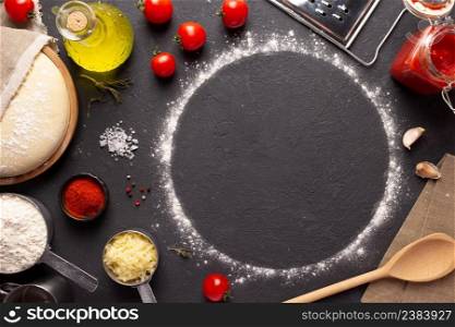 Homemade pizza and flour with ingredients at table. Dough for pizza on tabletop background. Recipe concept in kitchen