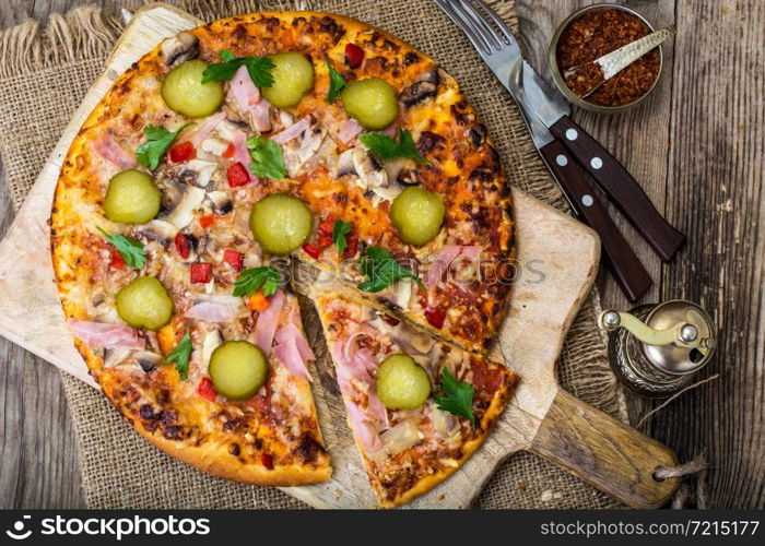 Homemade pizza with ham and mushrooms. Studio Photo. Homemade pizza with ham and mushrooms