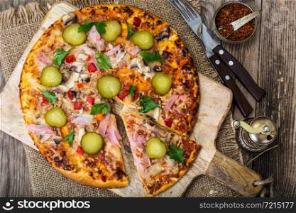Homemade pizza with ham and mushrooms. Studio Photo. Homemade pizza with ham and mushrooms