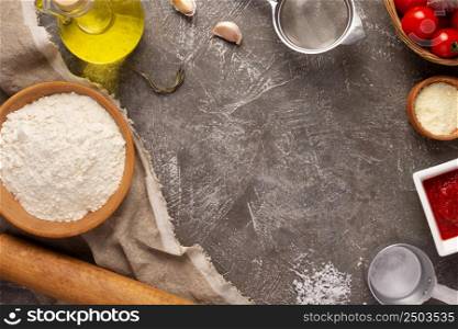 Homemade pizza with ingredients at table. Flour for pizza on tabletop background. Recipe concept in kitchen