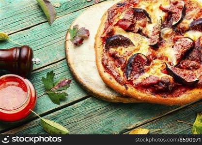 Homemade pizza with meat and autumn figs. Pizza with meat and fruits