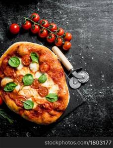 Homemade pizza with sausages, tomatoes and cheese. On dark rustic background. Homemade pizza with sausages, tomatoes and cheese.