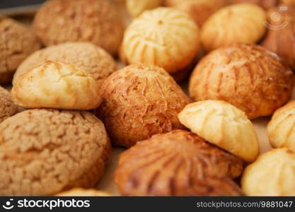 Homemade profiteroles on the music sheet with notes. Profiteroles  choux a la creme  - French choux pastry balls filled with custard or cottage cheese sprinkled with powdered sugar