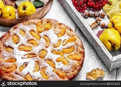 Homemade quince pie. Cake with harvest autumn quince on light wooden background