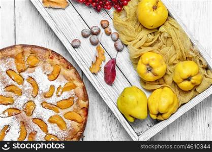 Homemade quince pie. Cake with harvest autumn quince on light wooden background