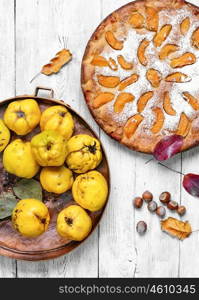 Homemade quince pie. Cake with harvest autumn quince on light wooden background