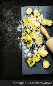 Homemade raw Italian tortellini on dark vintage background