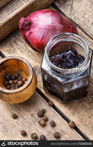 Homemade red onion jam.Onion confiture on old wooden table. Onion jam in glass jar