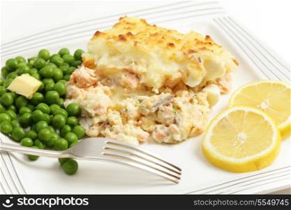 Homemade salmon, egg and potato pie, served with boiled peas and garnished with slices of lemon