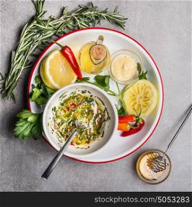 Homemade sauce or salad dressing in bowl with ingredients: fresh herbs, oil, lemon and honey, top view, close up. Healthy , clean food or vegetarian cooking and eating concept