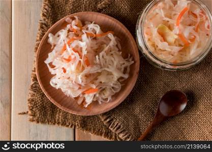 Homemade sauerkraut on a linen background. Rustic style, canned vegetables on a light wooden background. Eco food, the trend of healthy eating.