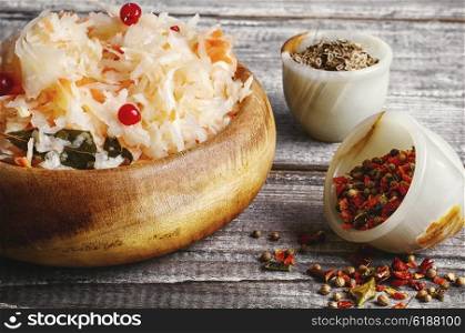 Homemade sauerkraut. Wooden barrel with sauerkraut and scattered on a background of spices