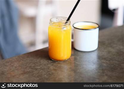 Homemade sea buckthorn lemonade in jar and cup of tea with shallow depth of field