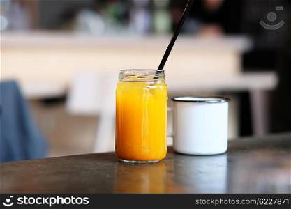Homemade sea buckthorn lemonade in jar and cup of tea with shallow depth of field