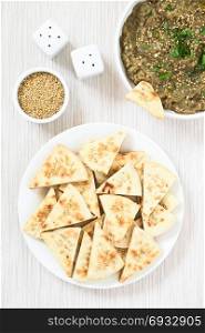 Homemade sesame pita chips with roasted eggplant dip or spread, baba ganoush in the Mediterranean cuisine on the side, photographed overhead with natural light. Sesame Pita Chips with Roasted Eggplant Dip