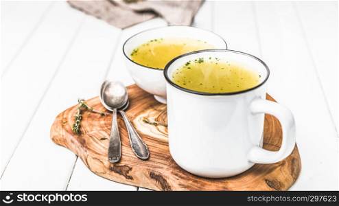 Homemade simple soup in a white cup against colds