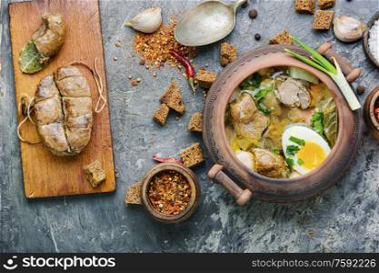 Homemade soup with meat, egg and sausage.. Meat soup in a clay pot