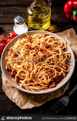 Homemade spaghetti bolognese in a plate. On a wooden background. High quality photo. Homemade spaghetti bolognese in a plate.