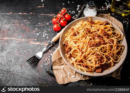 Homemade spaghetti bolognese in a plate on the table. Against a dark background. High quality photo. Homemade spaghetti bolognese in a plate on the table.