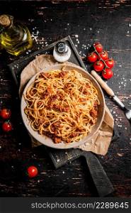 Homemade spaghetti bolognese in a plate on the table. Against a dark background. High quality photo. Homemade spaghetti bolognese in a plate on the table.
